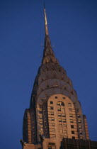 Part view of the Chrysler Building from East 42nd Street lit by golden light.  Steel framed Art Deco skyscraper built 1928-1930 and designed by architect William Van Alen.