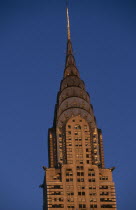 Part view of the Chrysler Building from East 42nd Street lit by golden light.  Steel framed Art Deco skyscraper built 1928-1930 and designed by architect William Van Alen.