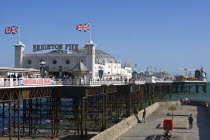 Brighton Pier on a sunny  windy day with a groyne alongside it.