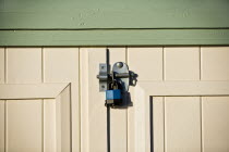 Close-up of a padlock on the wooden doors of a beach hut.