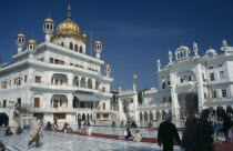 The Sri Takhat Sahib  Sikh Parliment building in the Golden Temple complex with groups of people gathered on marble floor