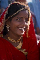 Portrait of a girl dancer smiling wearing red and gold at the Camel Festival