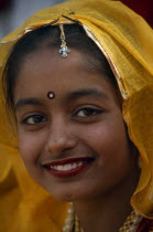 Head and shoulders portrait of a young girl smiling at the Alwar Utsav Festival