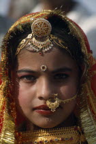 Head and shoulders portrait of a young girl wearing traditional jewellery at the Desert Festival