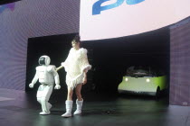 Tokyo Car Show  Asimo Robot and young woman introduce Honda concept car Puyo