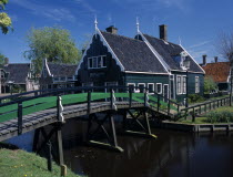 Footbridge leading to a typical green wooden house in the village