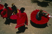 Aymara Andean Indian dancers wearing red skirts and ponchos during marriage festivities