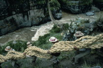 Men from the Chumbivilcas hills carrying length of thick rope made from woven grass to make main cable or trense used for bridge construction by local villagers