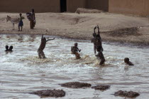 Tuareg children playing in rain pool.