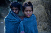Portrait of two young girls wrapped in turquoise fabric.