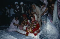 Bride and groom receiving gifts of money from guests during wedding ceremony.