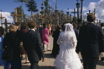 Wedding group in front of hundreds of crosses and crucifix at ancient pilgrimage site near Siaulial.