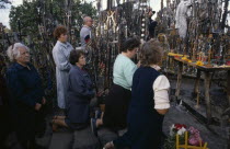 Men and women pray in front of hundreds of crosses and crucifix at ancient pilgrimage site near Siaulial.