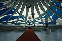 Cathedral Metropolitana interior with stained glass ceiling and suspended aluminium angels designed by Alfredo Scesciatte.  People on seating in front of altar below.