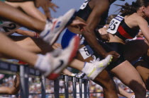 Cropped shot of competitors in hurdle race.