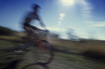 Cyclist on mountain bike in blur of movement.