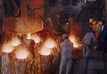 Interior of steel works with male workers.