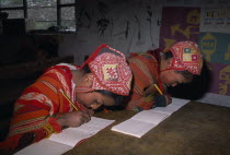 Tastayoc Village.  Quechua Indian children wearing traditional clothing  in school writing at desk.