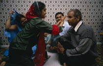 Daughter placing red mark on the forehead of her father during Hindu Sacred Thread Ceremony.