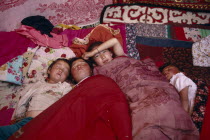 Kazakh children asleep in their kigizuy tent made of felt.
