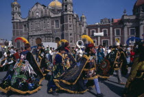 Celebrations for Our Lady of Guadaloupe outside the Basilica with dancers in costume.