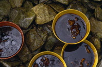 Tamales and bowls of chocolate and chilli sauce.