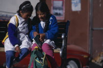 School girls share their homework.