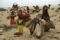 Bedouin people loading up camels to move camp
