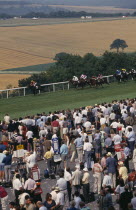 Crowds and line of bookmakers watching horse race at Goodwood racecourse on the South Downs.