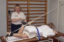 Female sport physiotherapist exercising female patients knee