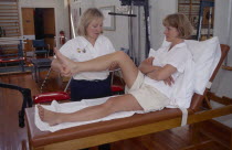 Female sport physiotherapist examining female patients knee