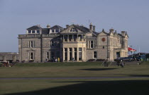 Golfers on green outside St. Andrews golf course clubhouse
