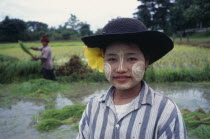 Karen girl with painted facial markings  rice paddy in background