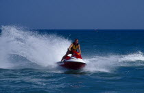 Man riding a jet ski on the sea at Littlehampton in West Sussex  England. Viewed from the front.