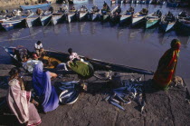Fishing harbour.  Women wait at harbourside while fishing boat unloads