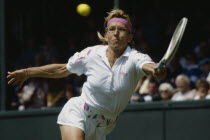 Martina Navratilova stretching for return during match at Wimbledon