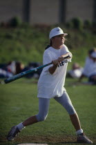 Female player at the plate swinging to strike the ball during the World Corporate Games in London in 1992