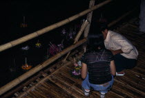 Yipeng Loi Krathong Festival  Lighting candles on Krathong to be floated on river for luck