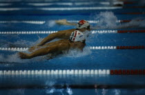 Male swimmers doing butterfly stroke in world student games.