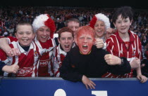 A group of young football supporters in red and white kit