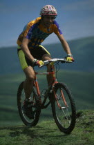 Young man on muddy mountain bike in the Lake District.