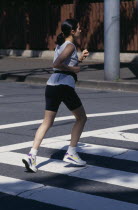 Female jogger on pedestrian crossing.