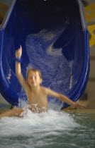 Boy sliding down waterchute