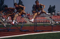 Competitor in men s hurdles during school championships.