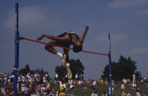 Competitor in men s high jump clearing bar.