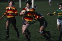 Junior boys team  player being tackled by the opposition.
