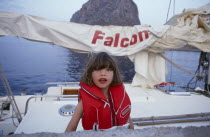 Greece. Monemvasia. An English family on a sailing holiday aboard their yacht with a young girl wearing a life jacket