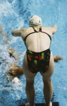 Female swimmer at race start in relay event