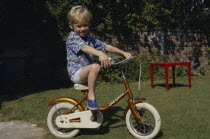Young boy riding a bicycle.