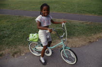 Young black girl on bicycle on Clapham Common.